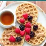Three mini waffles topped with peanut butter and berries.