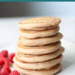 Stacked super fluffy eggless pancakes with raspberries on the side.
