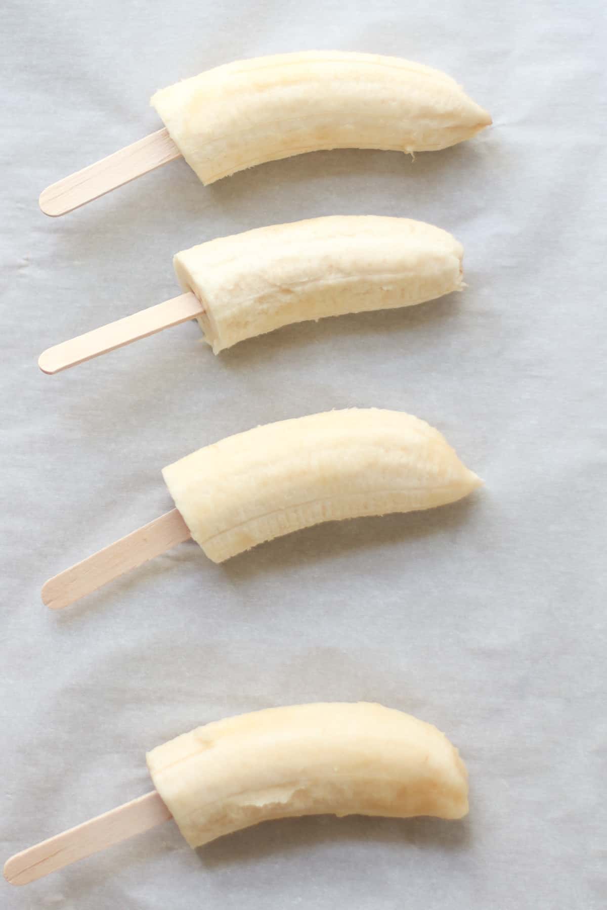 4 Banana halves with popsicle sticks.