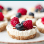 A close up shot of mini cheesecake topped with berries and sliced almonds.