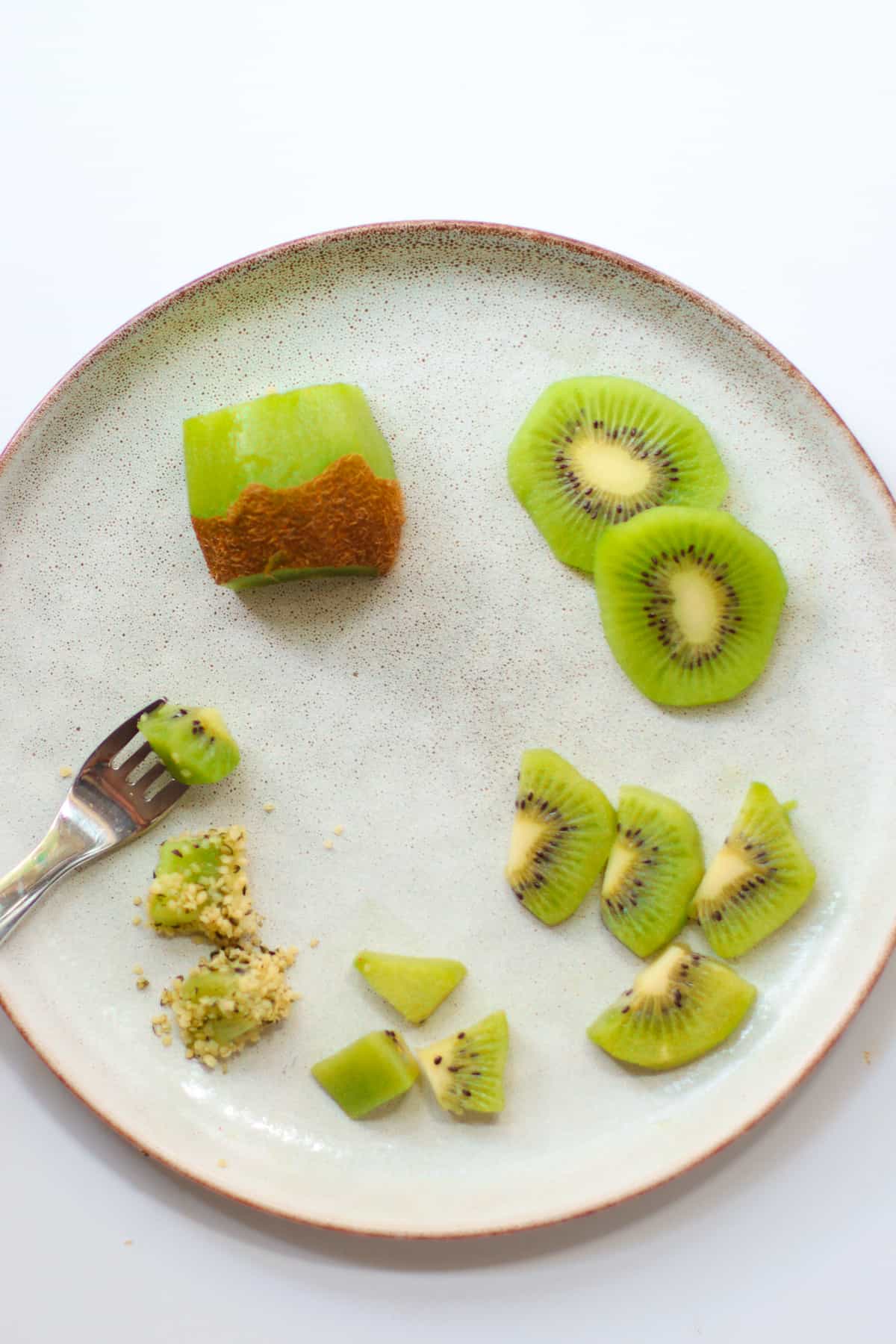 Kiwi sliced in appropriate ways for babies 6+ months and 9+ months.