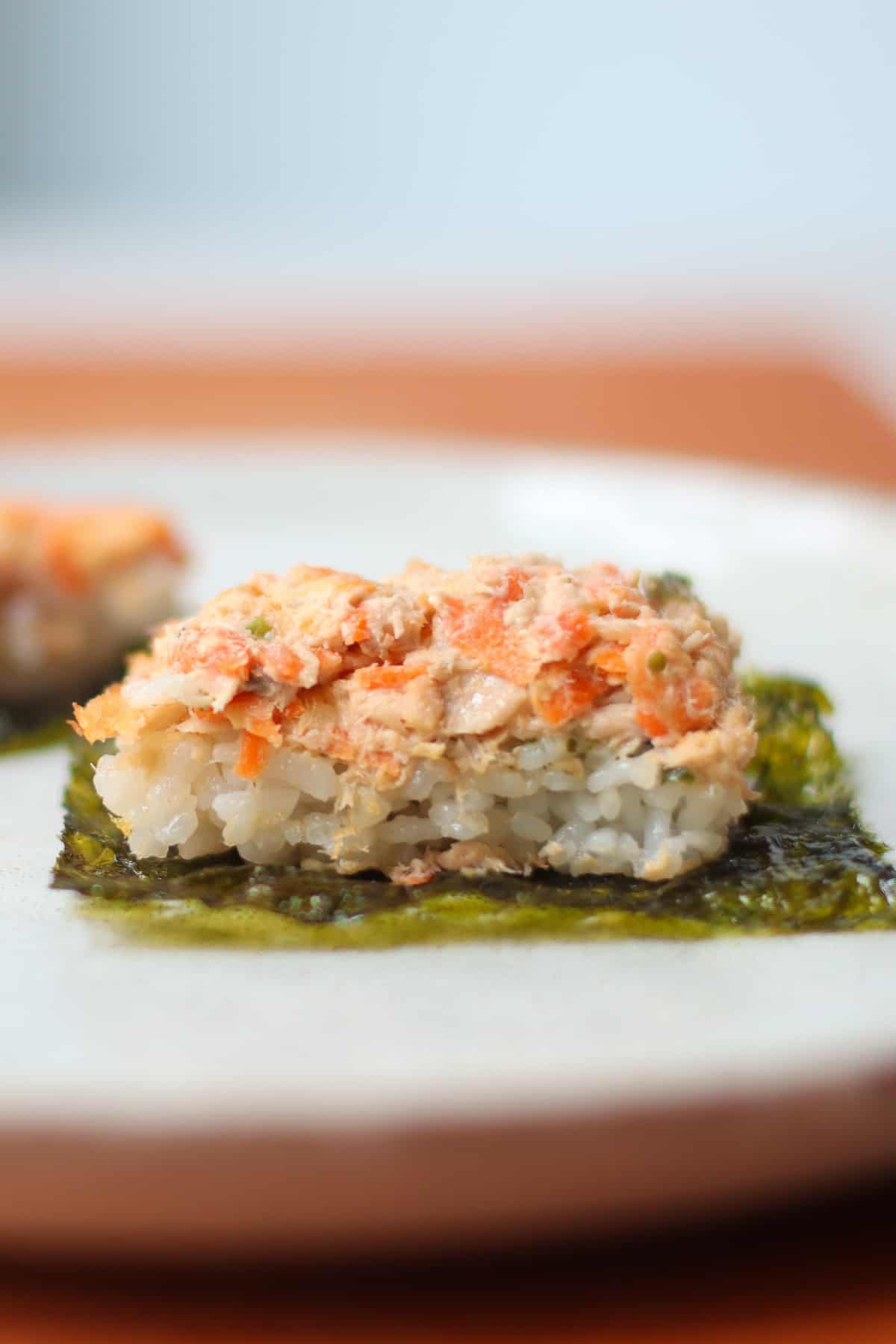 A close up shot of scooped sushi bake on top of seaweed sheet.