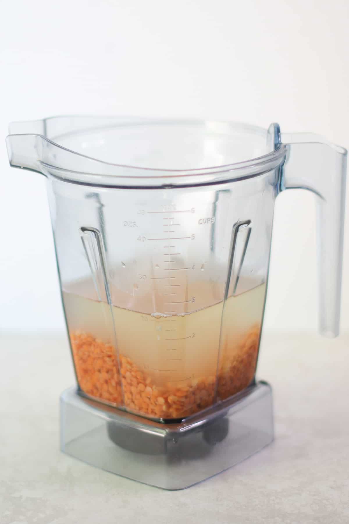 Red lentils with water in a blender.