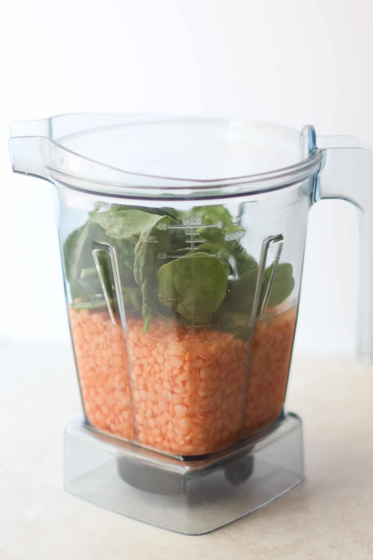 Soaked lentils with spinach in a blender.