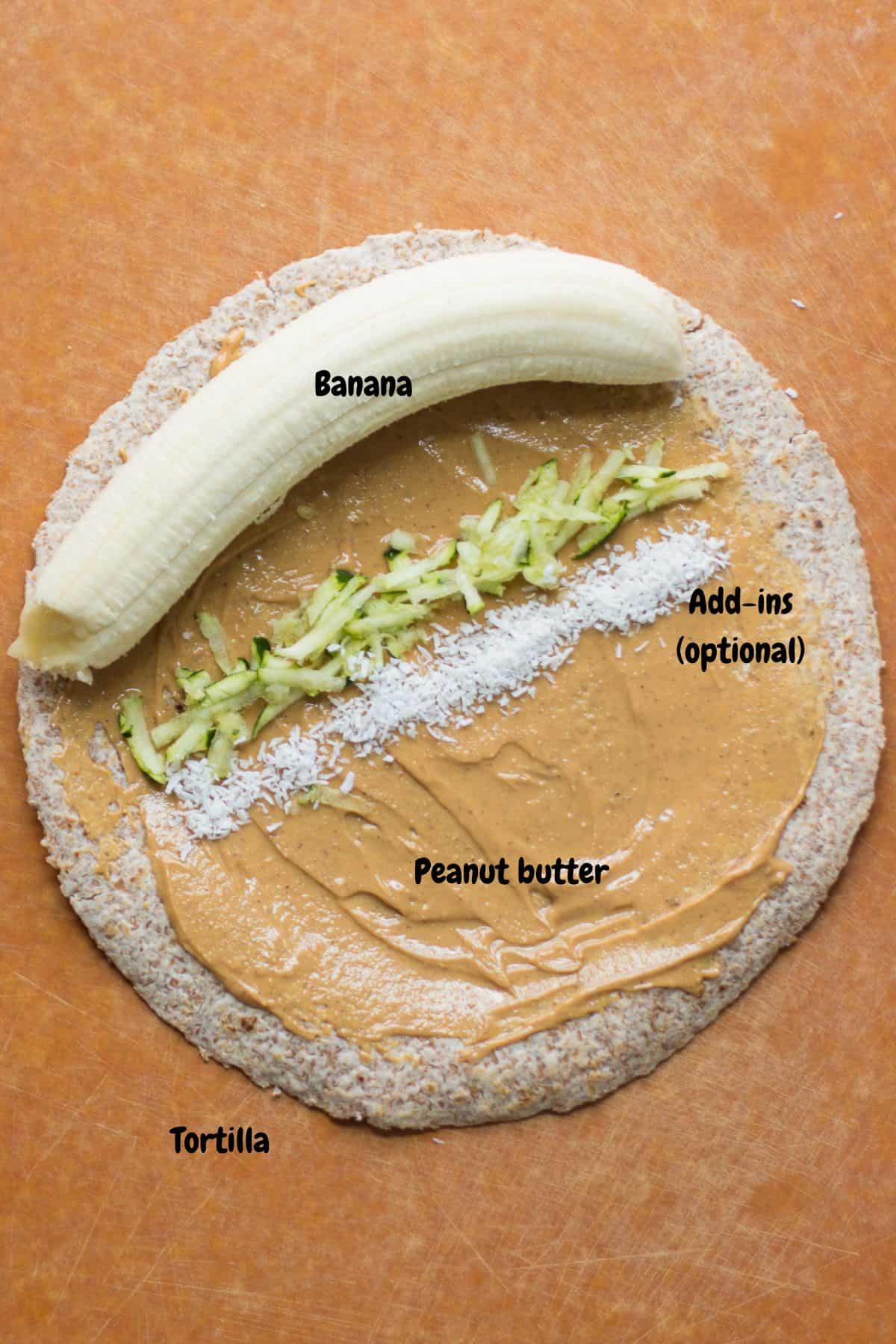 Peanut butter spread onto tortilla with banana, carrots, and coconut flakes.