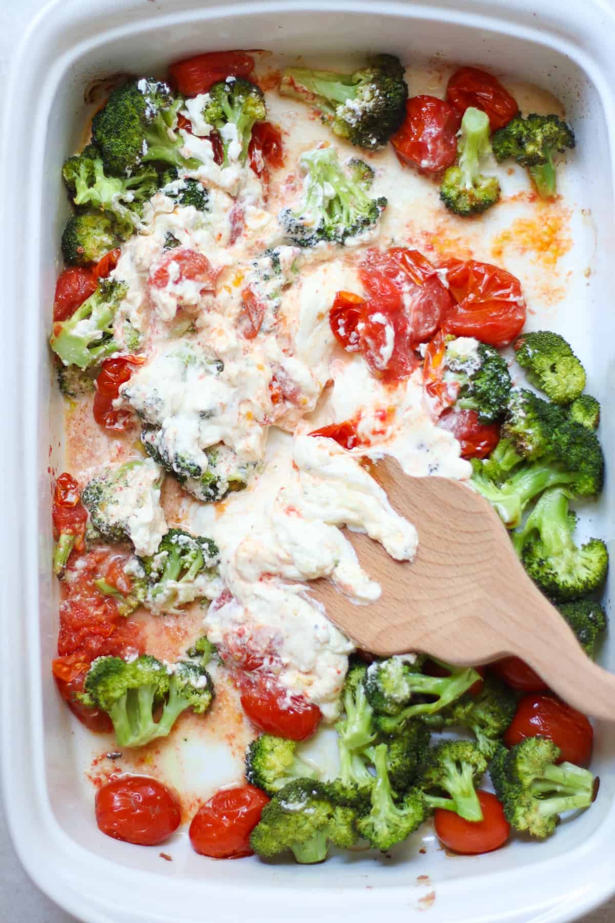 Smashing baked cream cheese with the tomatoes and broccoli.