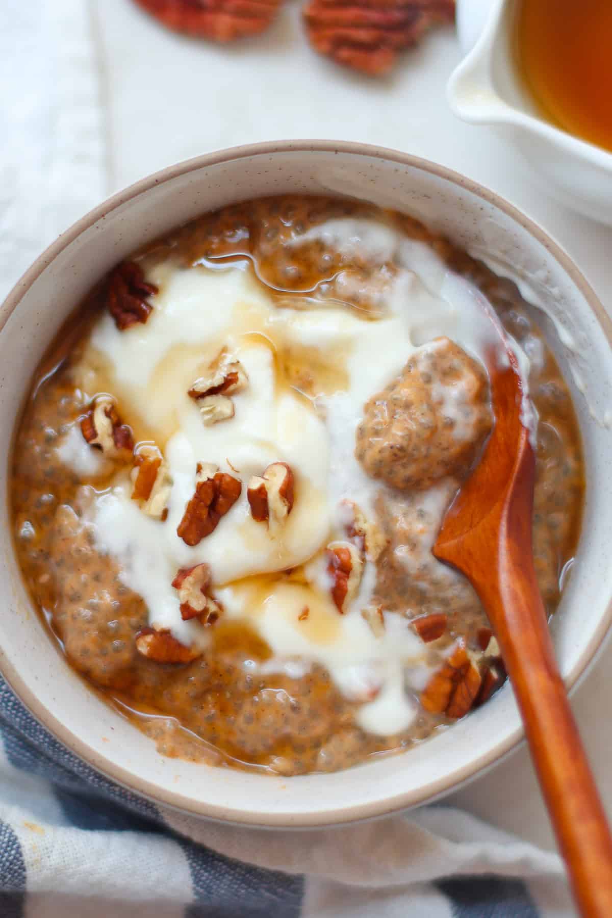 Pumpkin chia pudding with yogurt and chopped pecans in a large bowl.