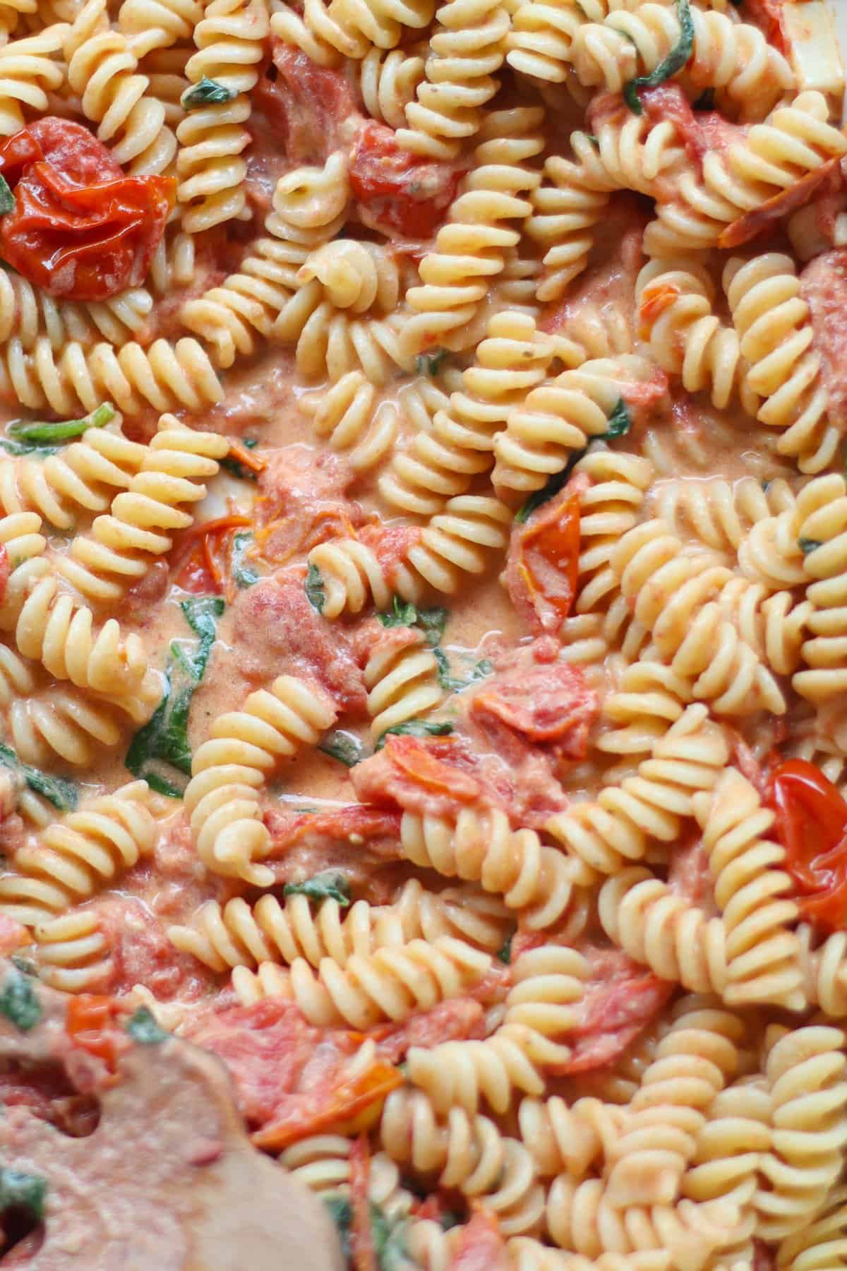 An up close shot of fusilit pasta in creamy sauce.