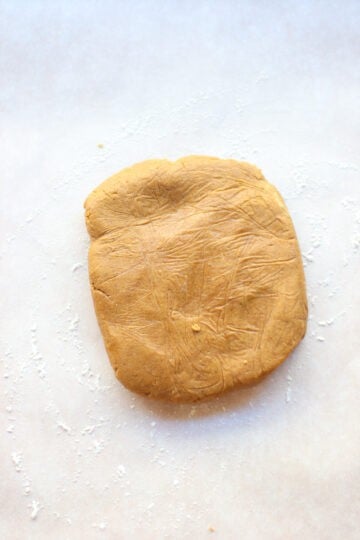 Cookie dough on a lightly floured parchment paper.