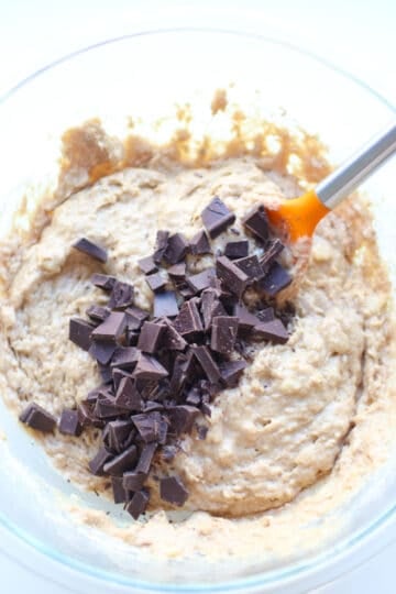 All ingredients including the chocolate chunks combined in a glass bowl.