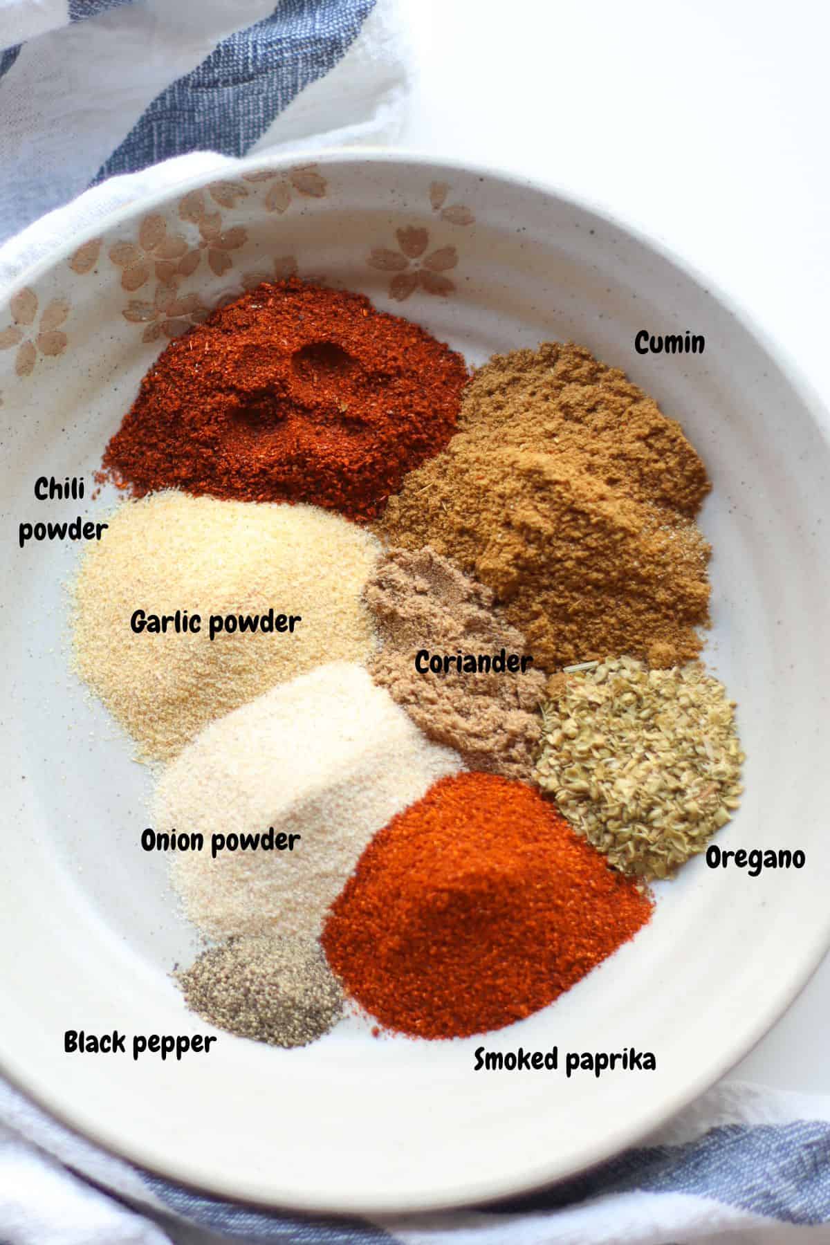 All the spices laid out on a plate and labeled.