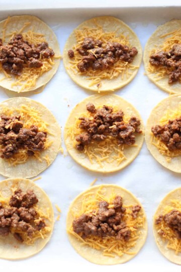 Tortillas topped with cheese and cooked ground beef mixture.
