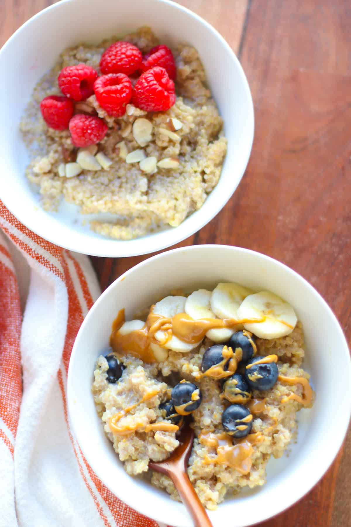 Two porridge bowls with berries and peanut butter drizzle.