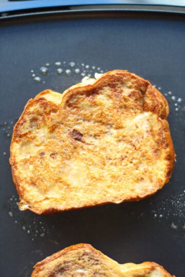 Close up of a cooked piece of stuffed french toast on the griddle.