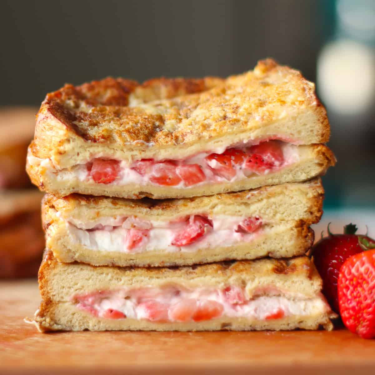 Close up of a stack of stuffed french toast with a strawberry cream cheese filling.