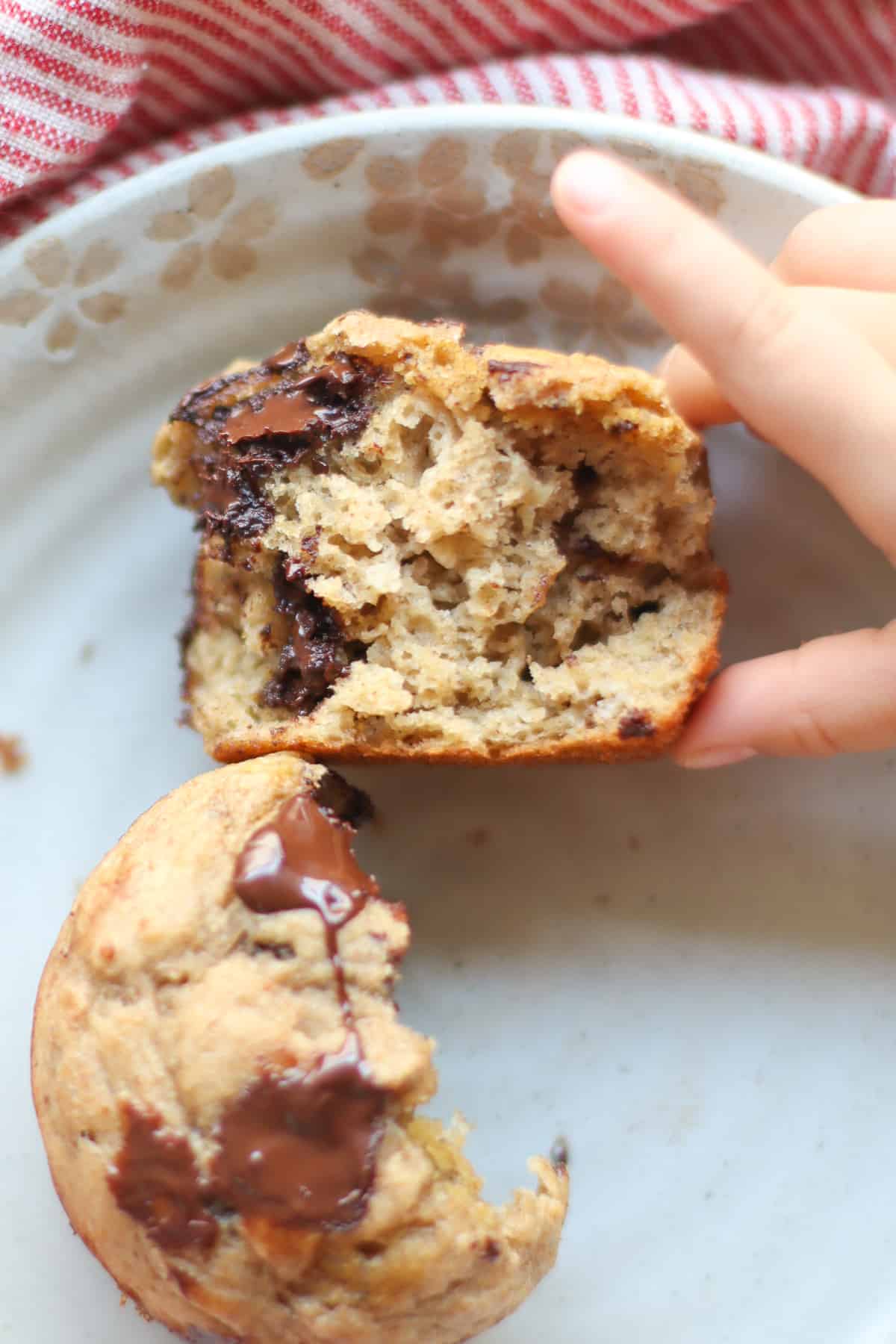 A baked muffin torn apart showing the inside on a plate.
