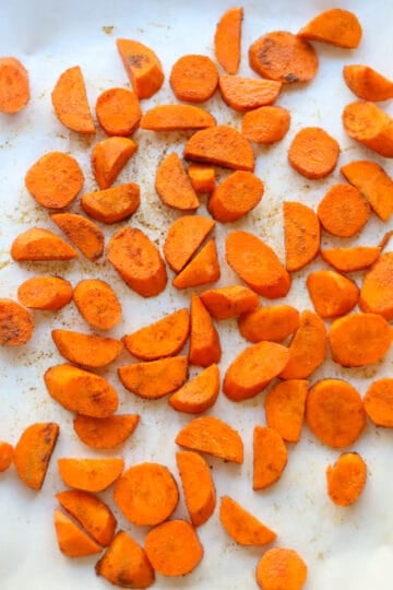 Sliced carrots on parchment before roasting.