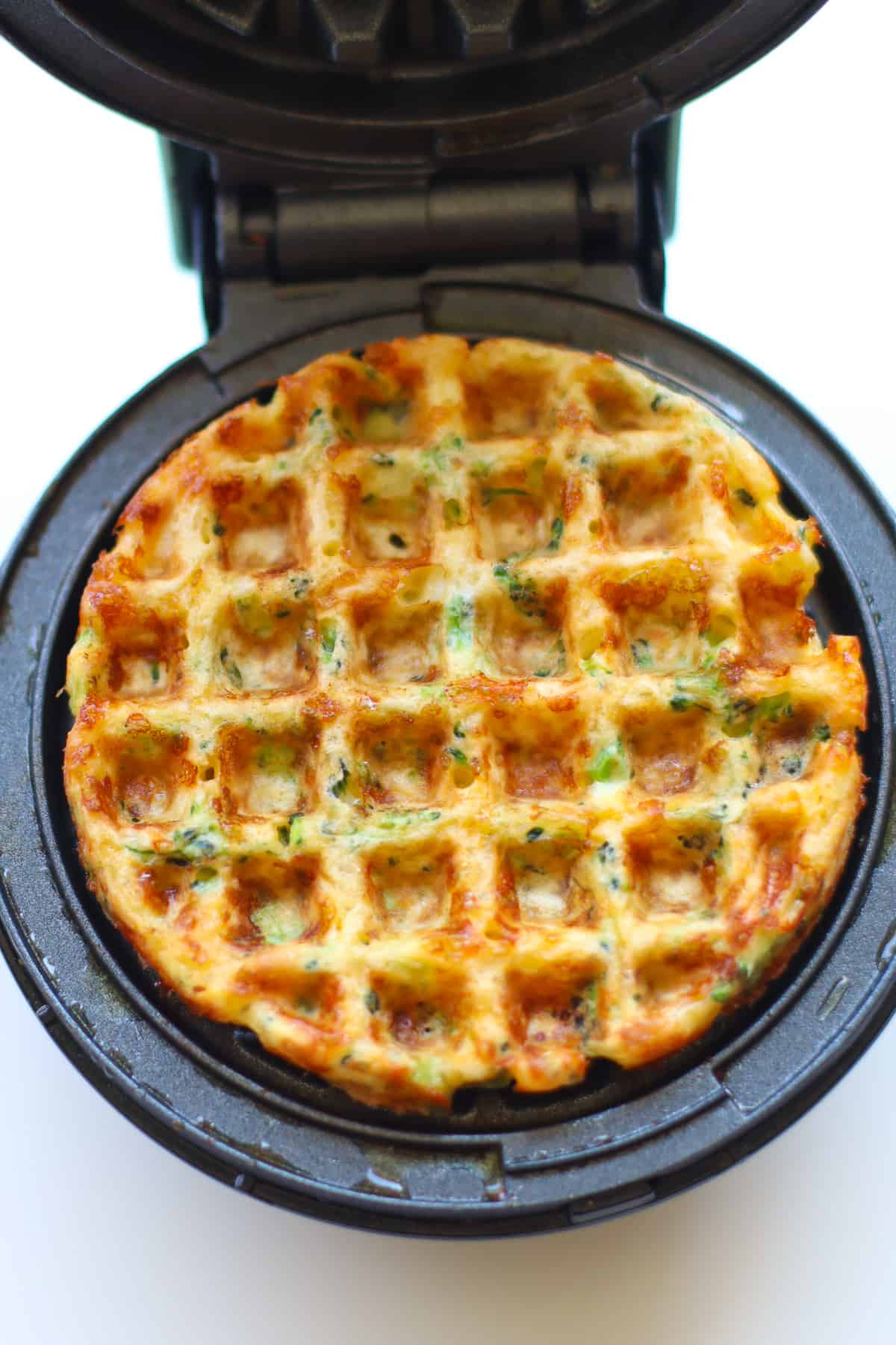 Cooked waffle in an open waffle maker.