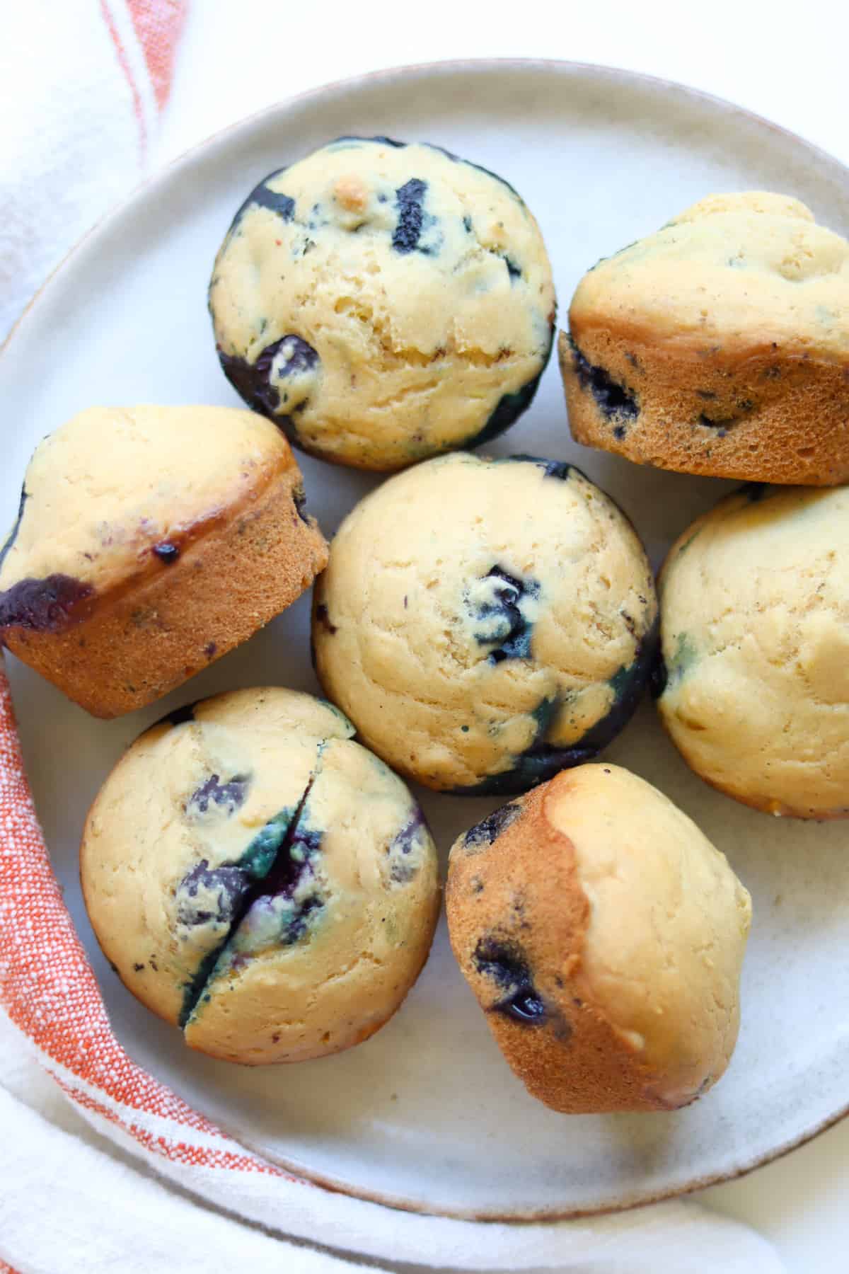 Baked blueberry muffins on a white plate.
