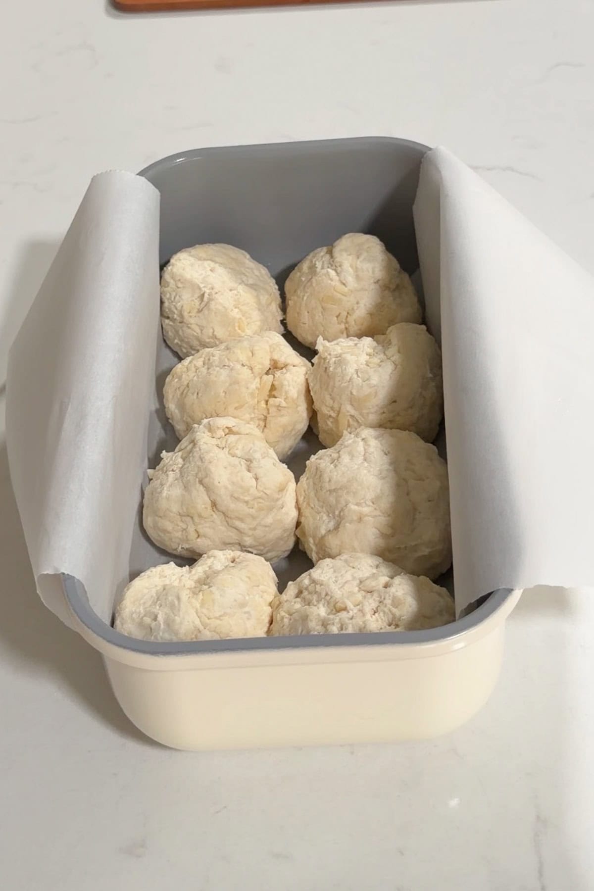 8 Cheese rolls added to a lined bread pan.