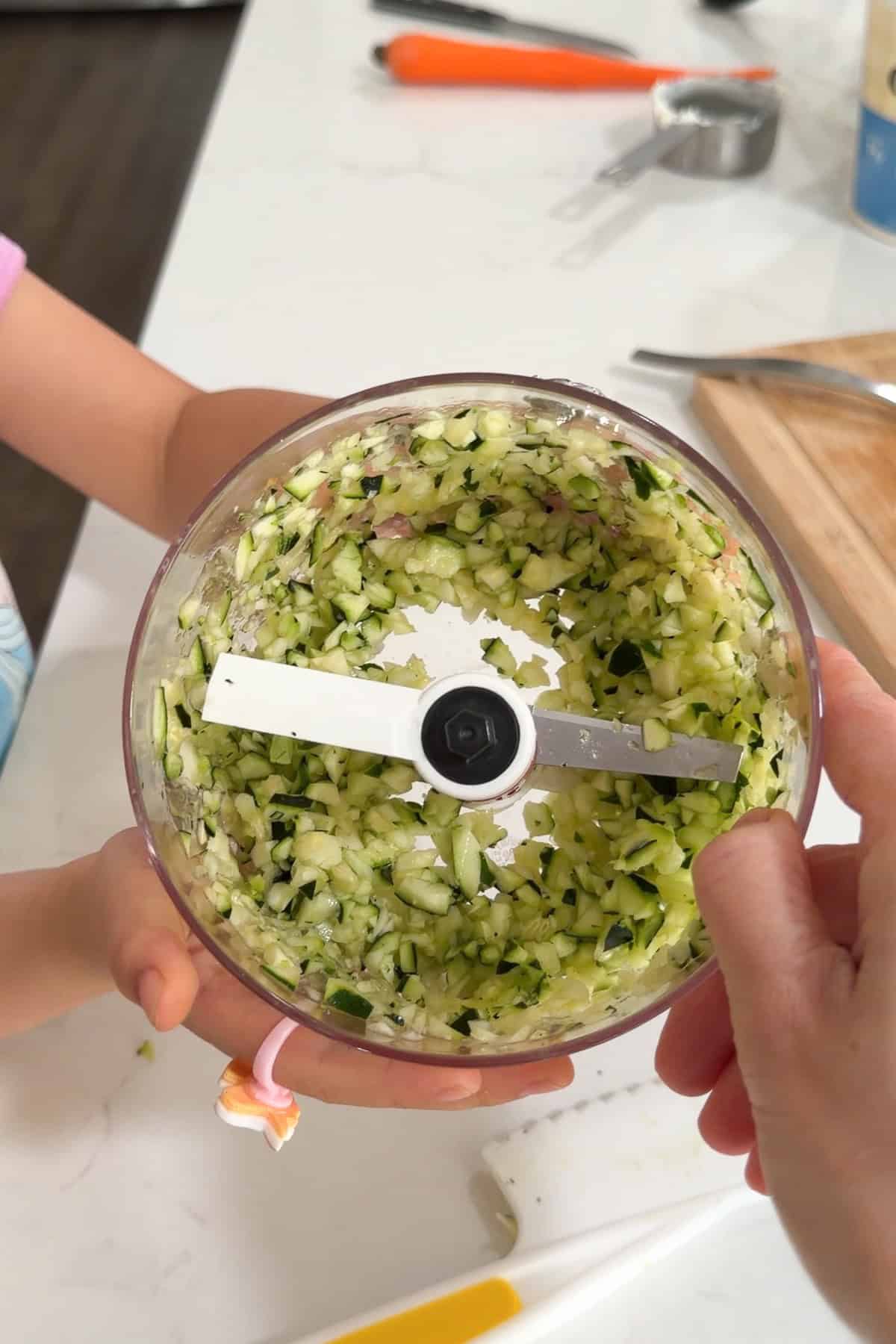 The vegetables being chopped in a food processor.