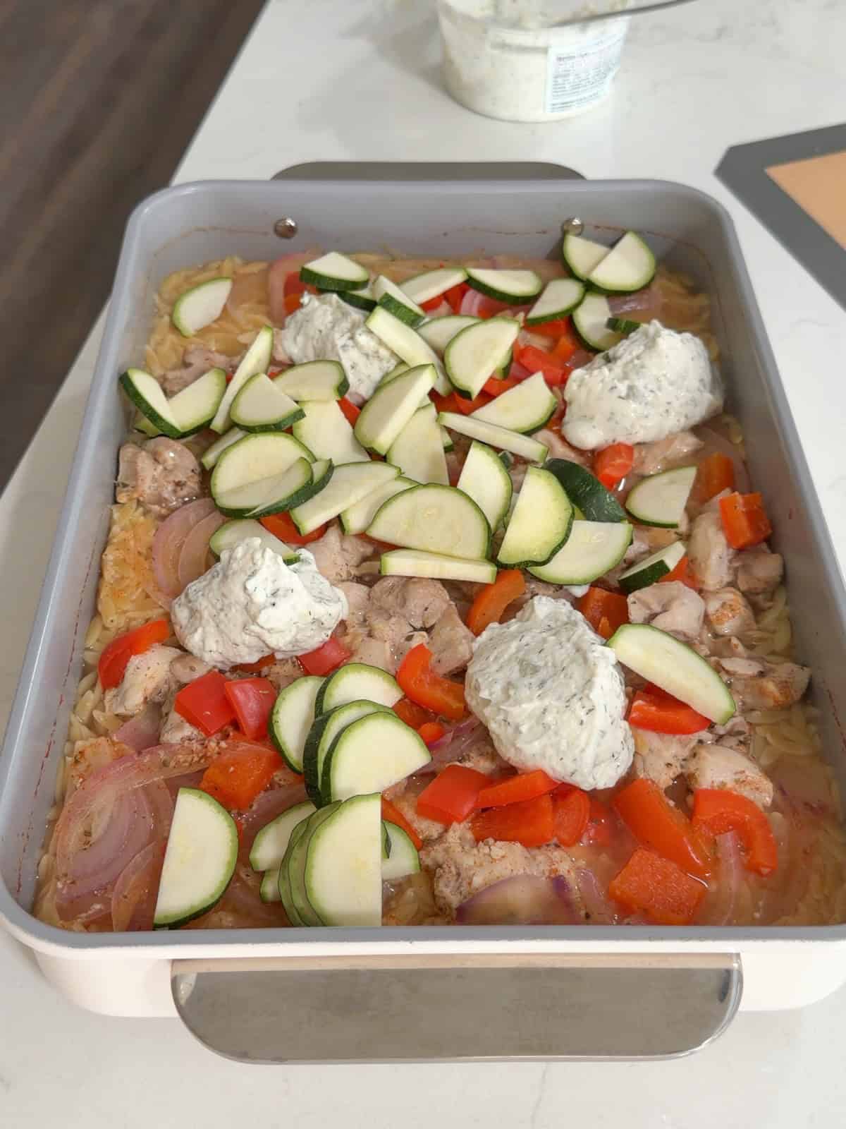 Cooked orzo topped with zucchini.