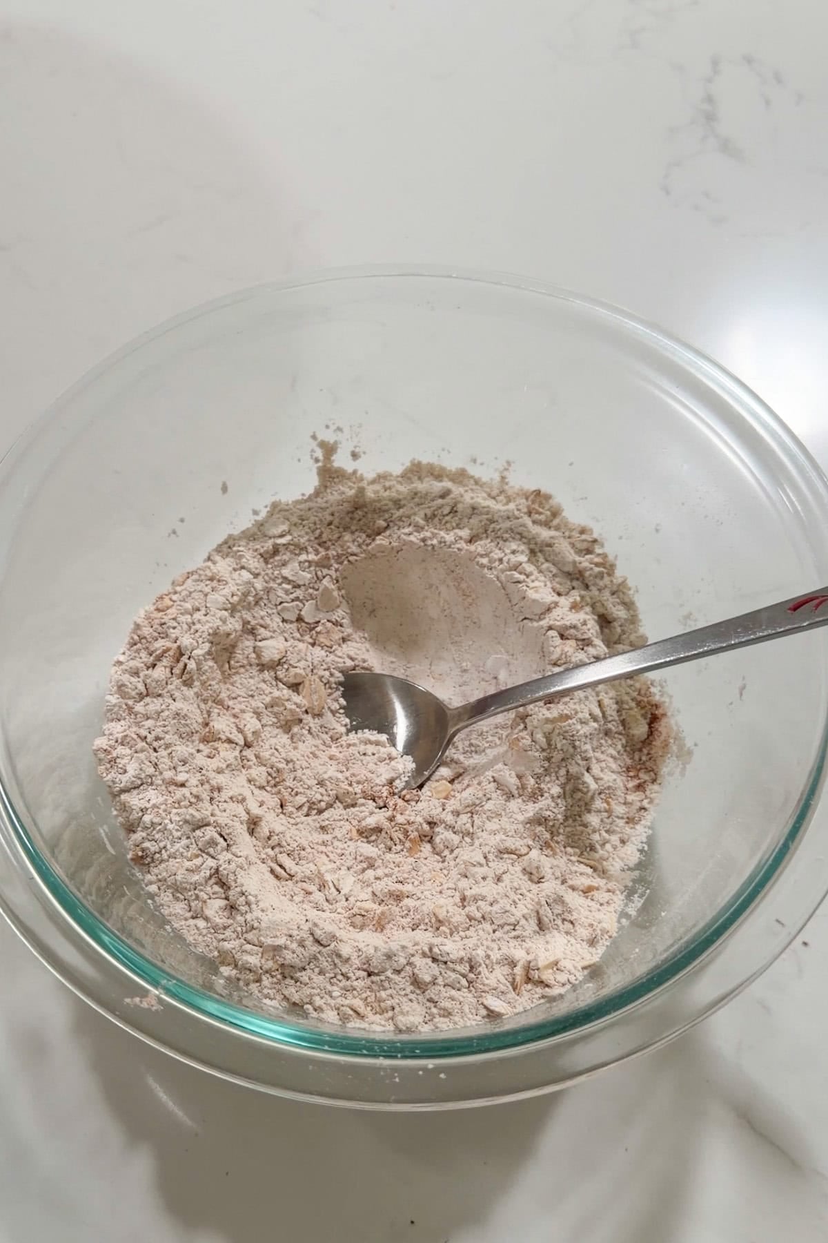 Dry ingredients added to a glass bowl.