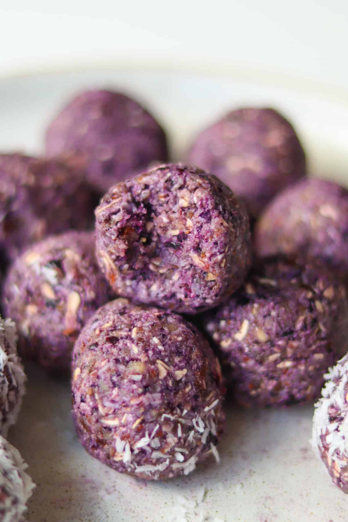 Blueberry bliss balls stacked on a plate.