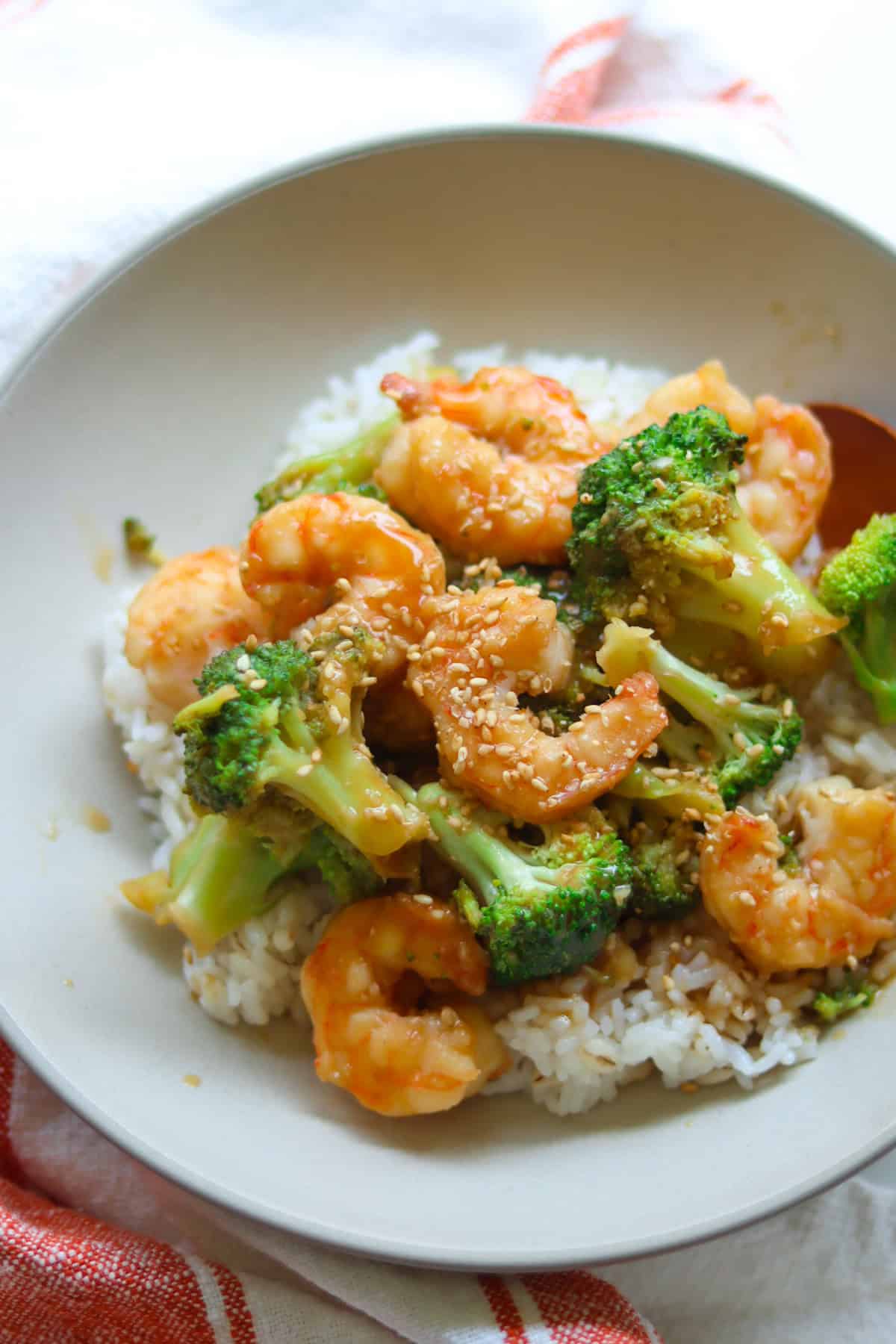 Shrimp broccoli stir fry over rice in a bowl.