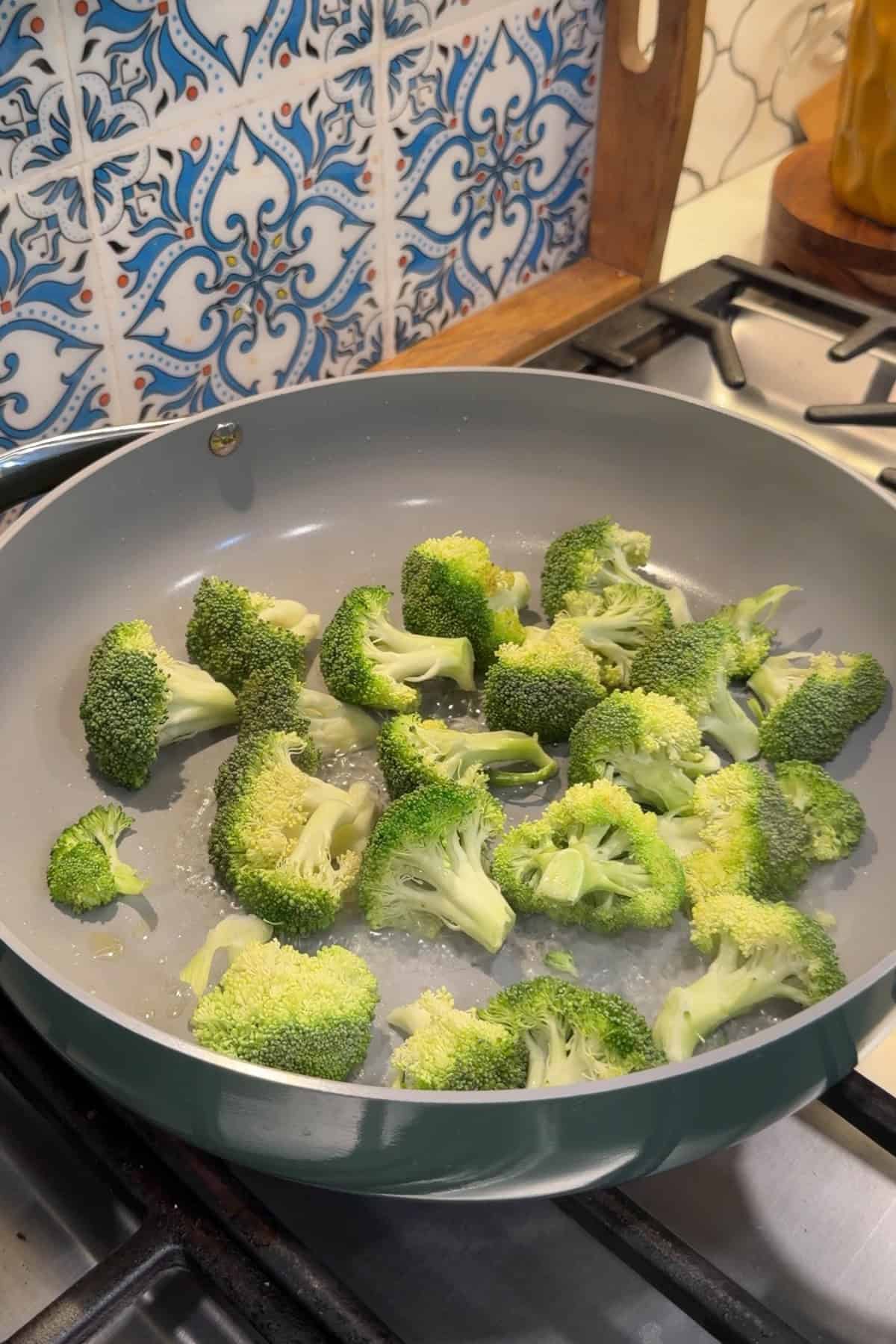 Broccoli cooking in a nonstick skillet.