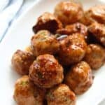 Cooked teriyaki meatballs on a white place.