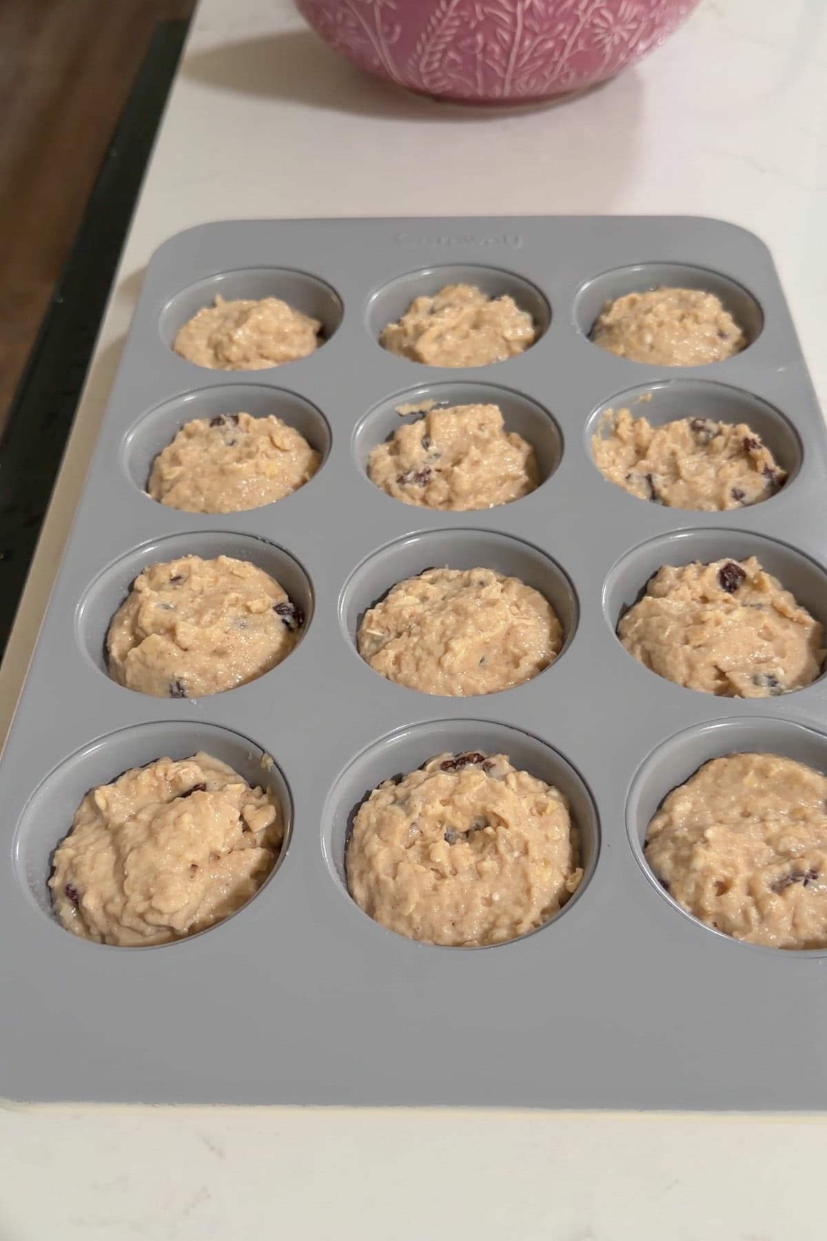 Muffin tin with batter divided evenly among all 12 cups.