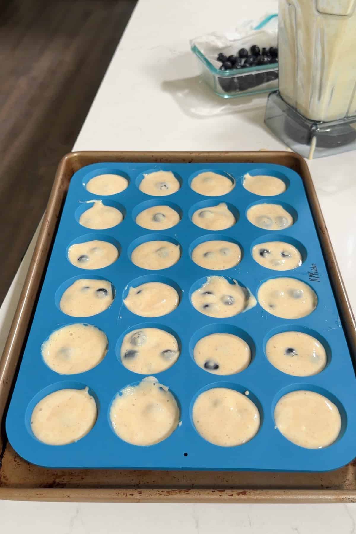 Cottage cheese bites in a blue silicone muffin pan ready to bake.
