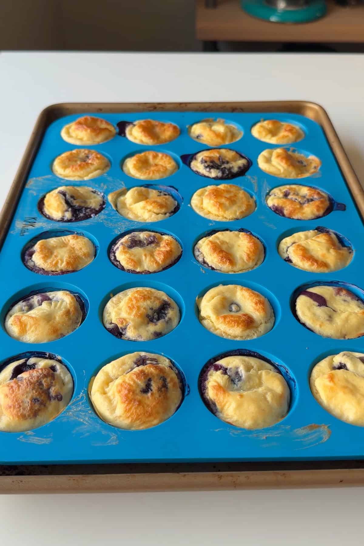 Baked cottage cheese bites in a blue mini silicone muffin pan.