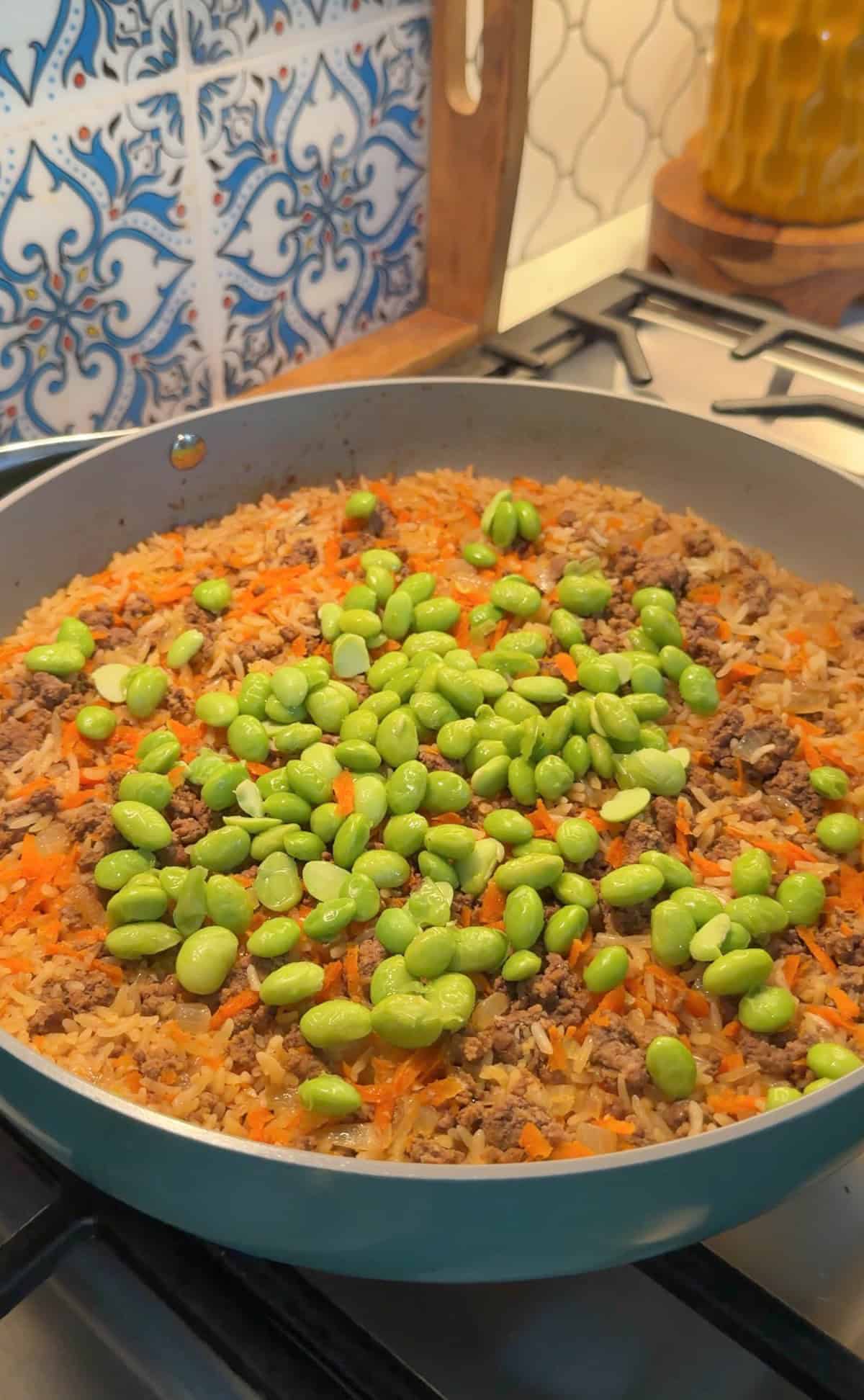 Edamame added to cooked rice.