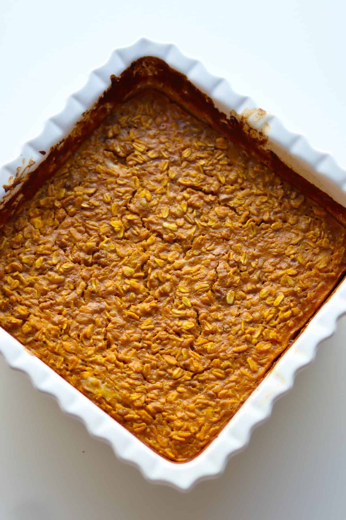 Baked oatmeal in white casserole dish.