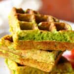 Three savory waffles stacked on a white plate.