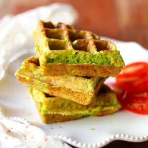 Three savory waffles stacked on a white plate.
