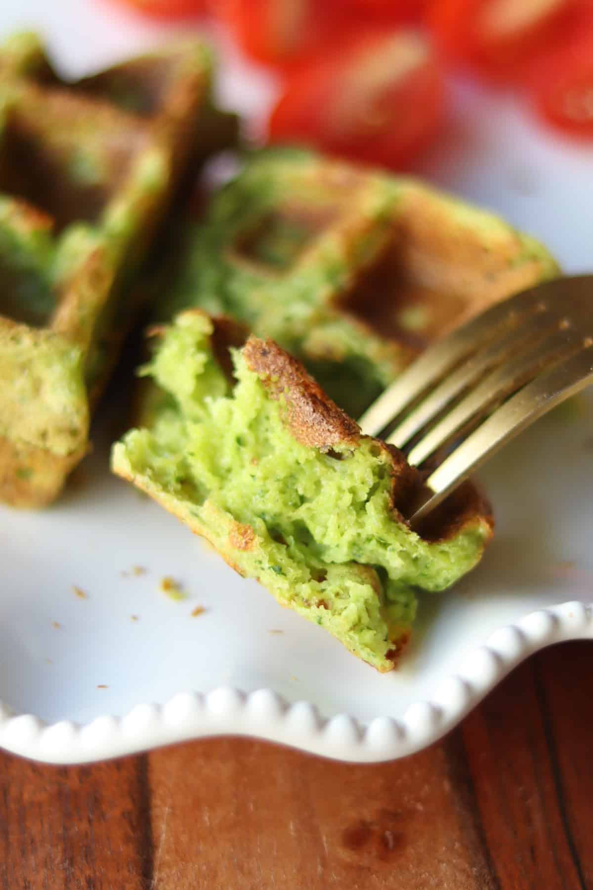 A piece of savory waffle forked on a white plate.