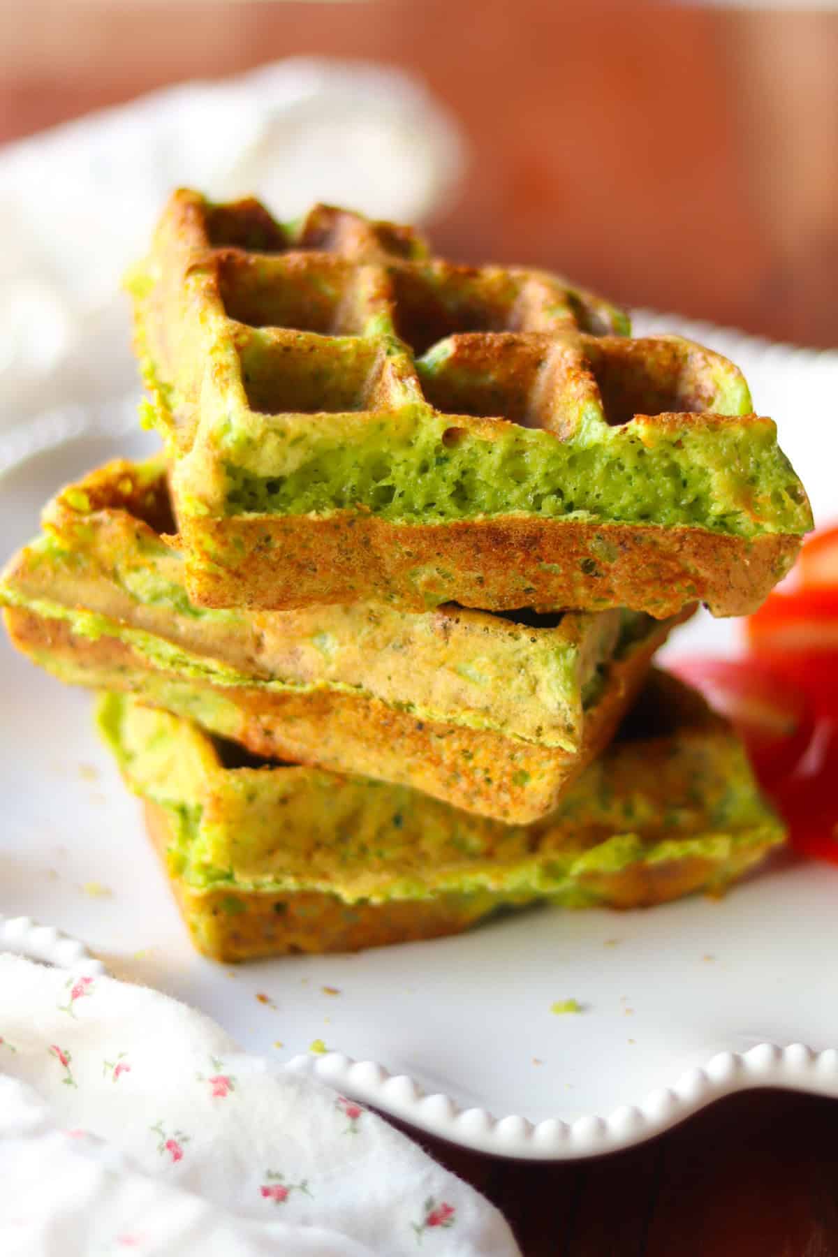 Three savory waffles stacked on a white plate.