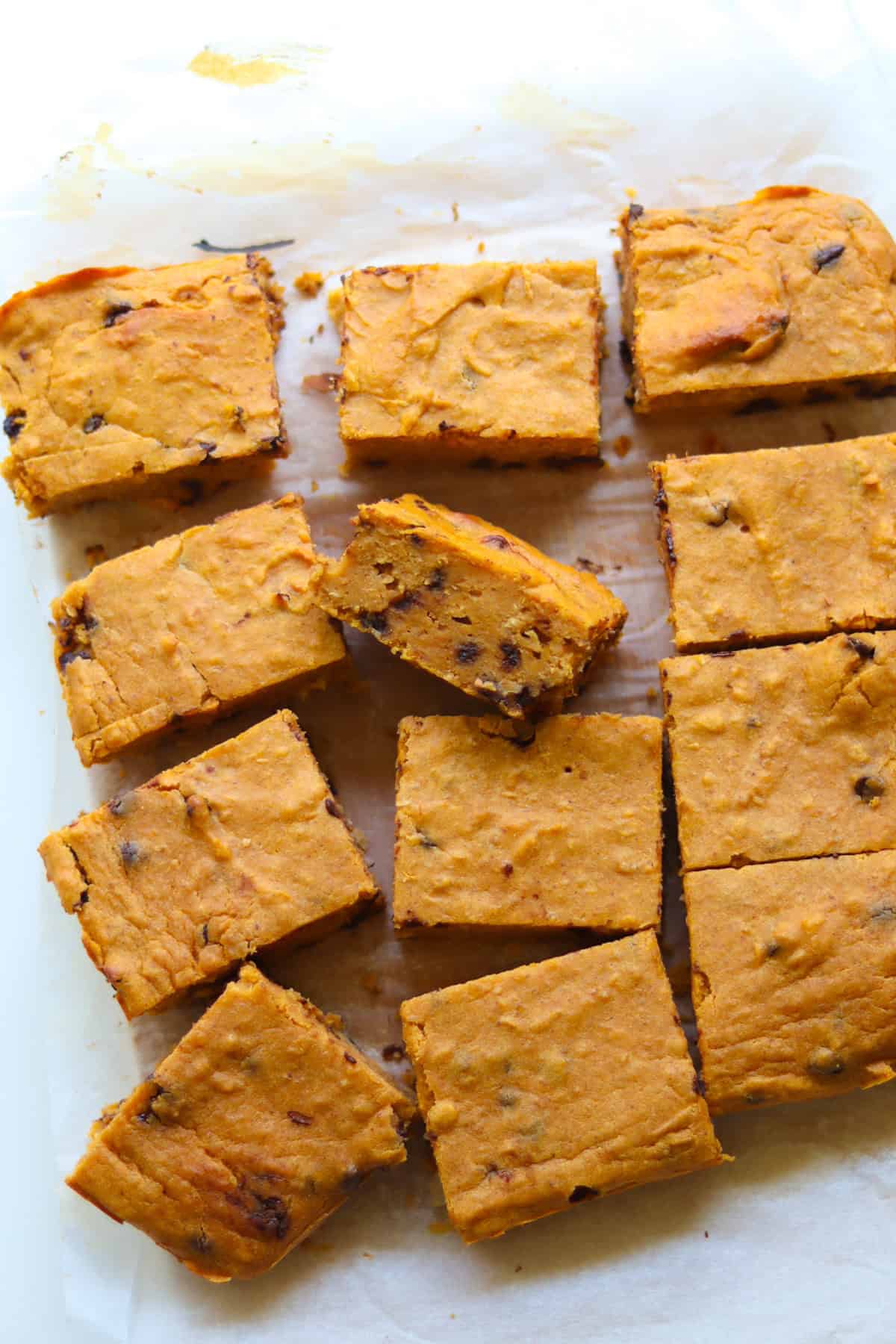 Sliced sweet potato bean blondies laid out on a parchment paper.
