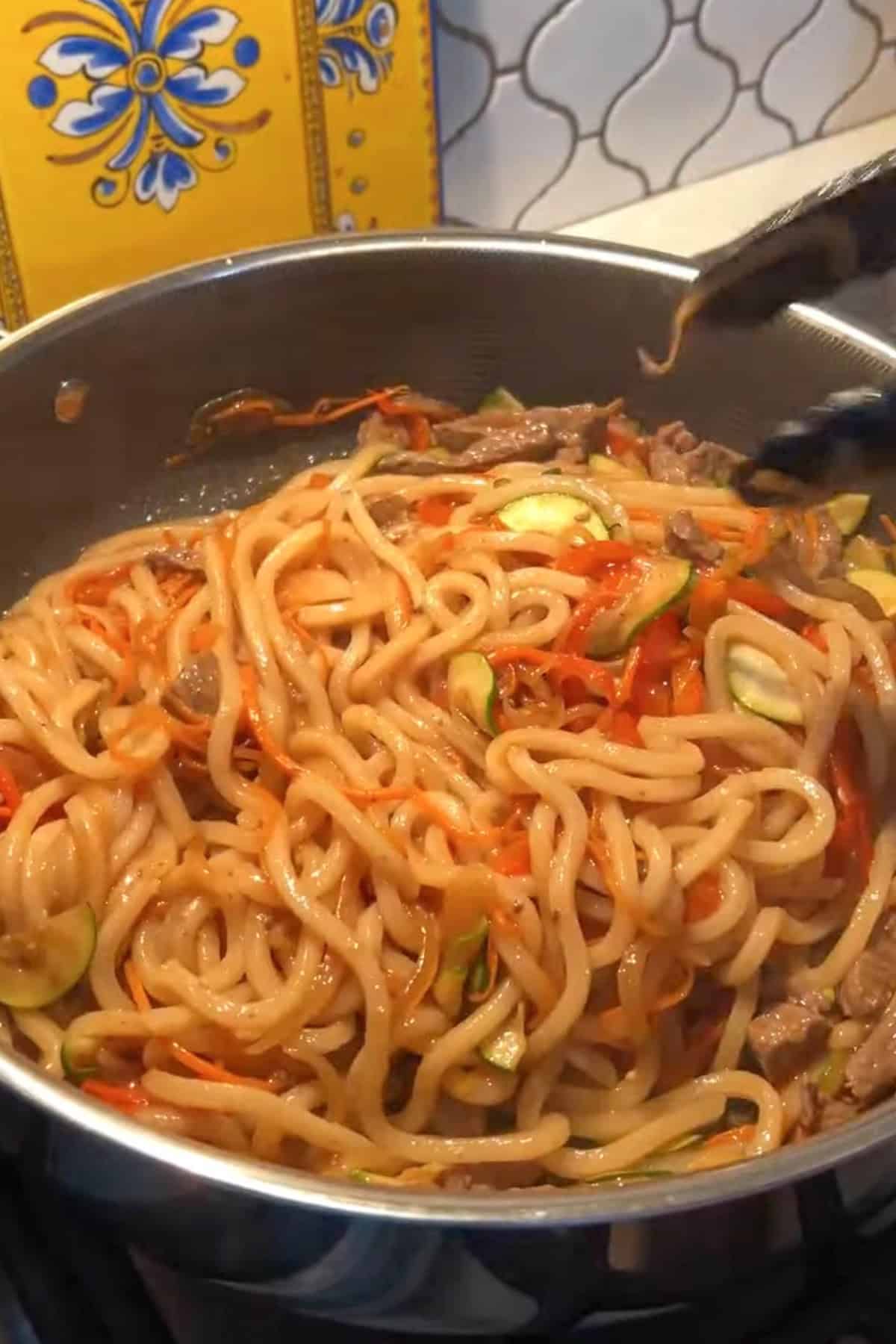 Udon noodles combined with sauce and vegetables.