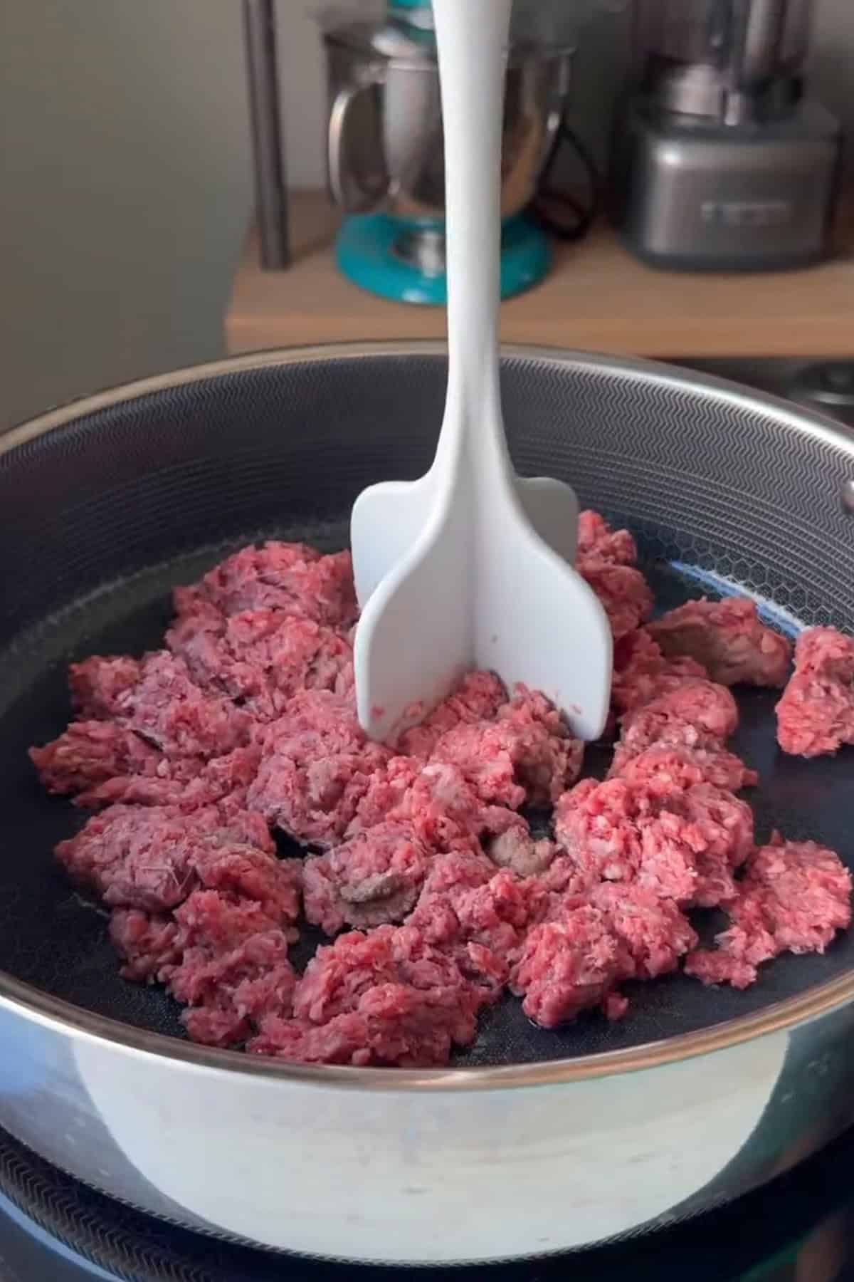 Ground beef cooking i a large pan.
