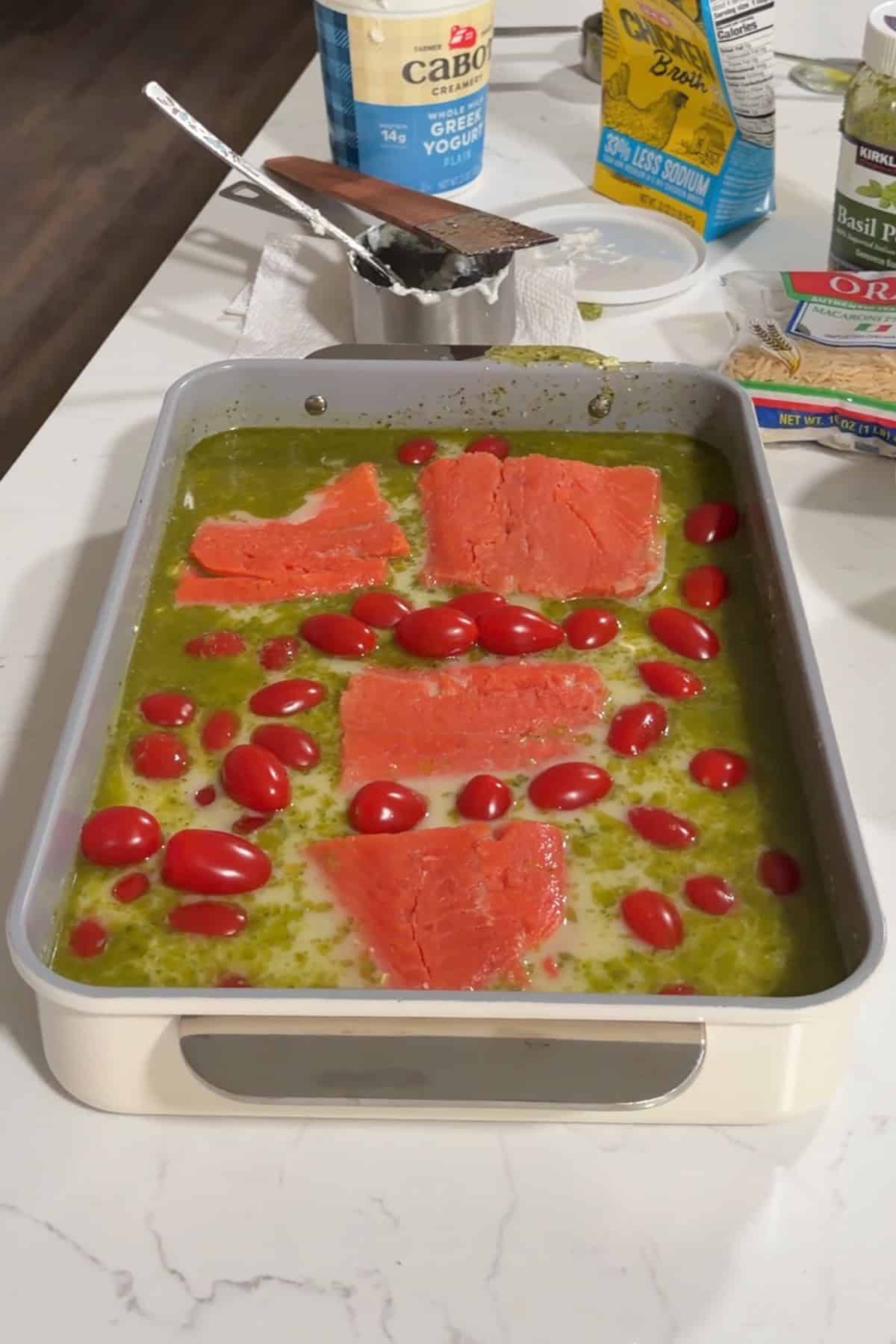 Cherry tomatoes and 4 salmon fillets laid on top.