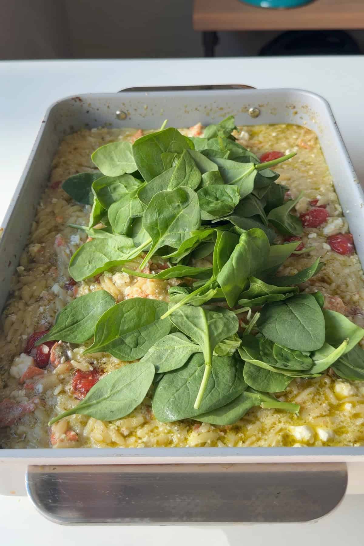 Spinach piled on top of cooked orzo.