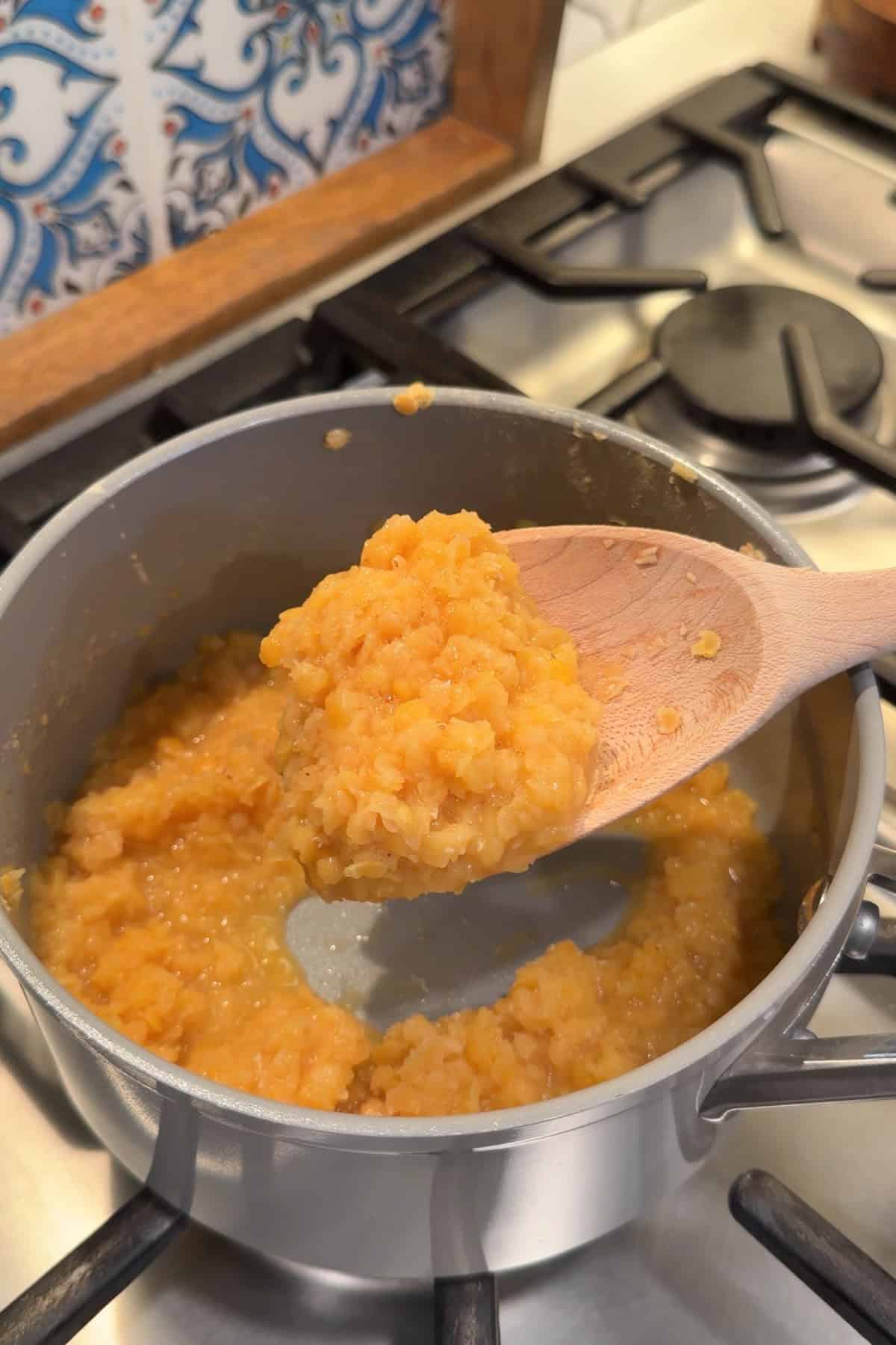Cooked red lentils in a small saucepan.