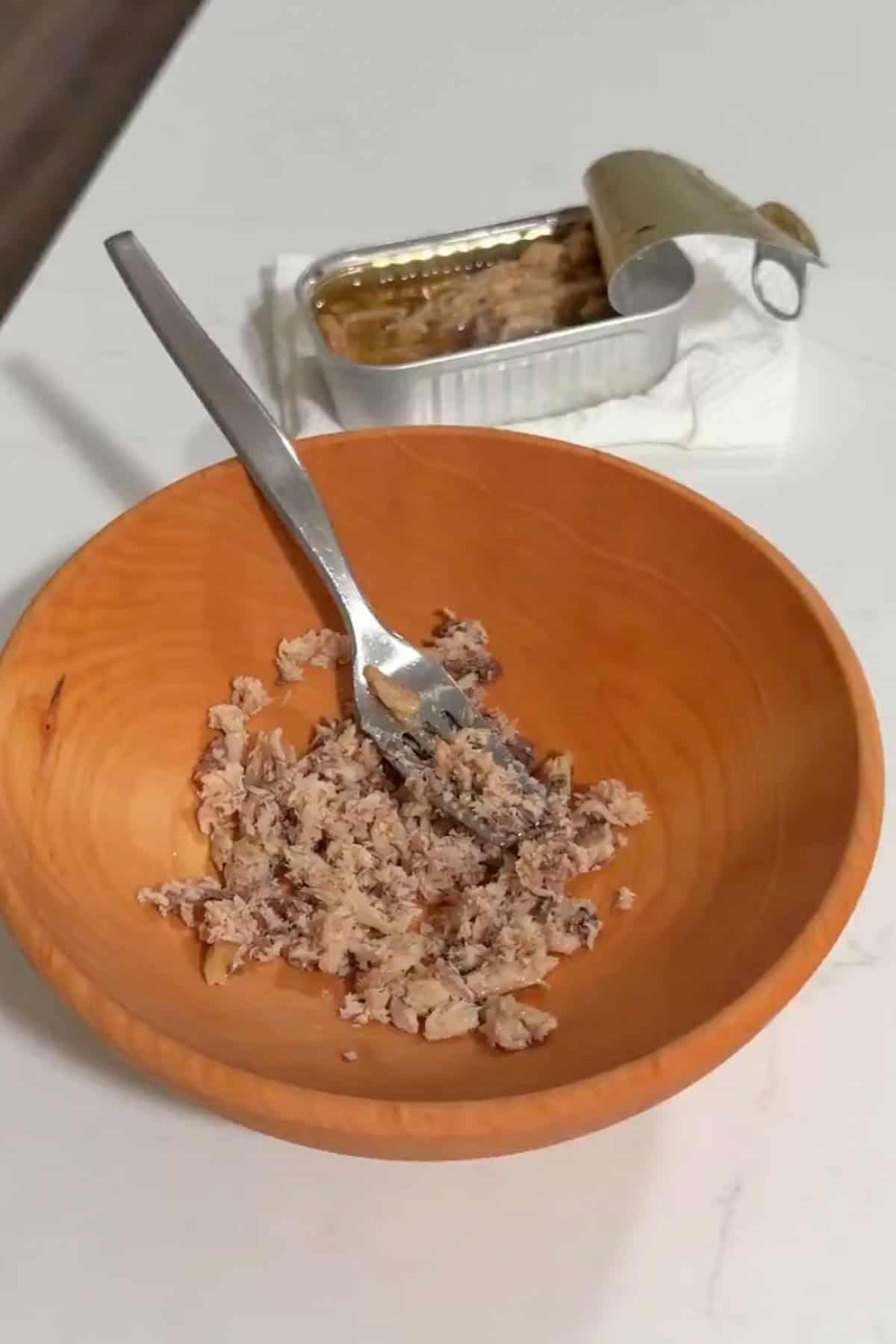 Sardines mashed in a wooden bowl.