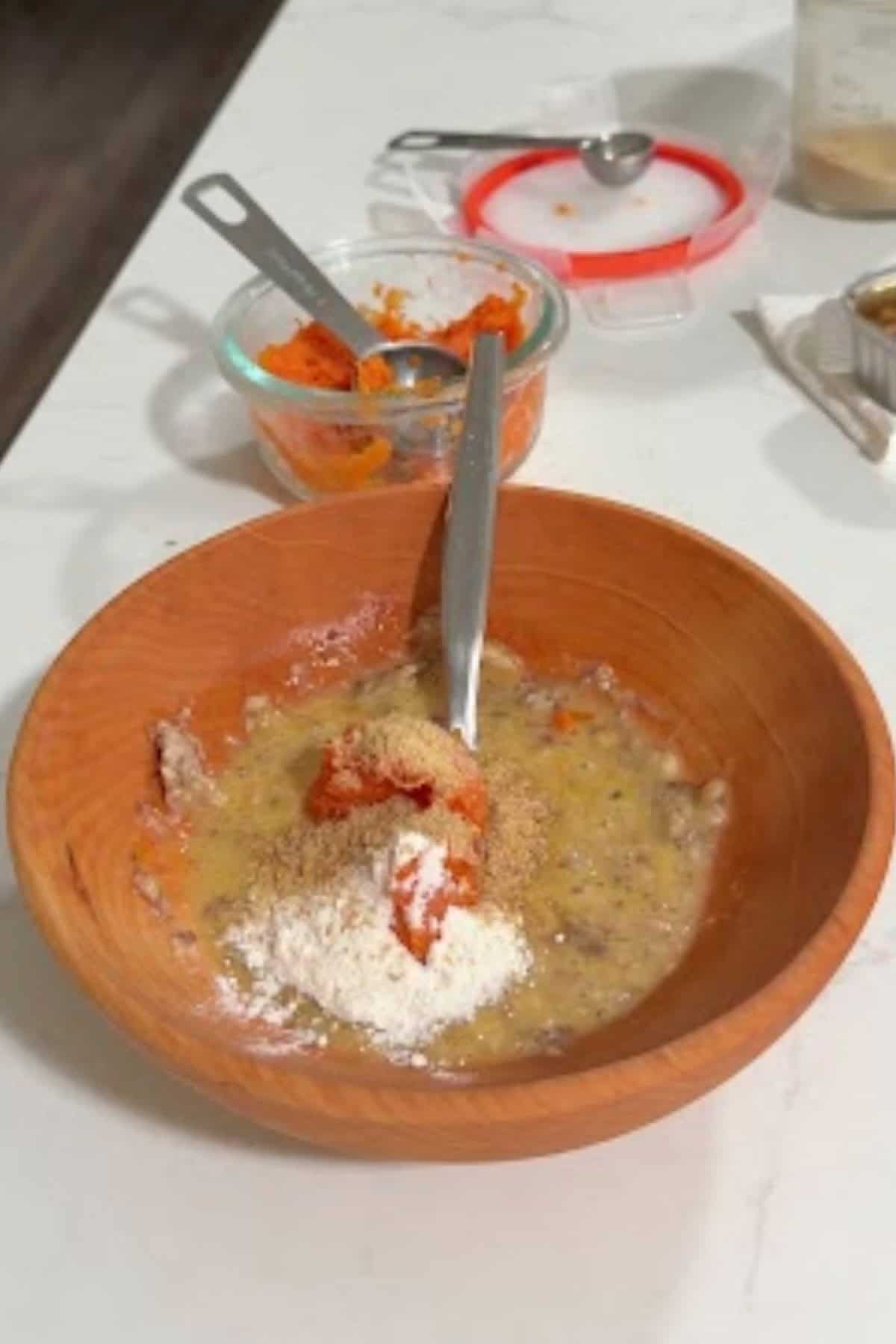 All the ingredients added to the sardines in a wooden bowl.